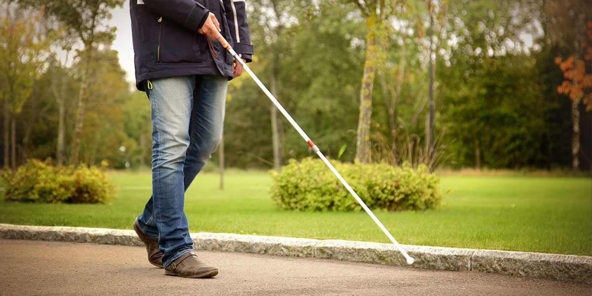 En mann som går tur med en mobility stokk